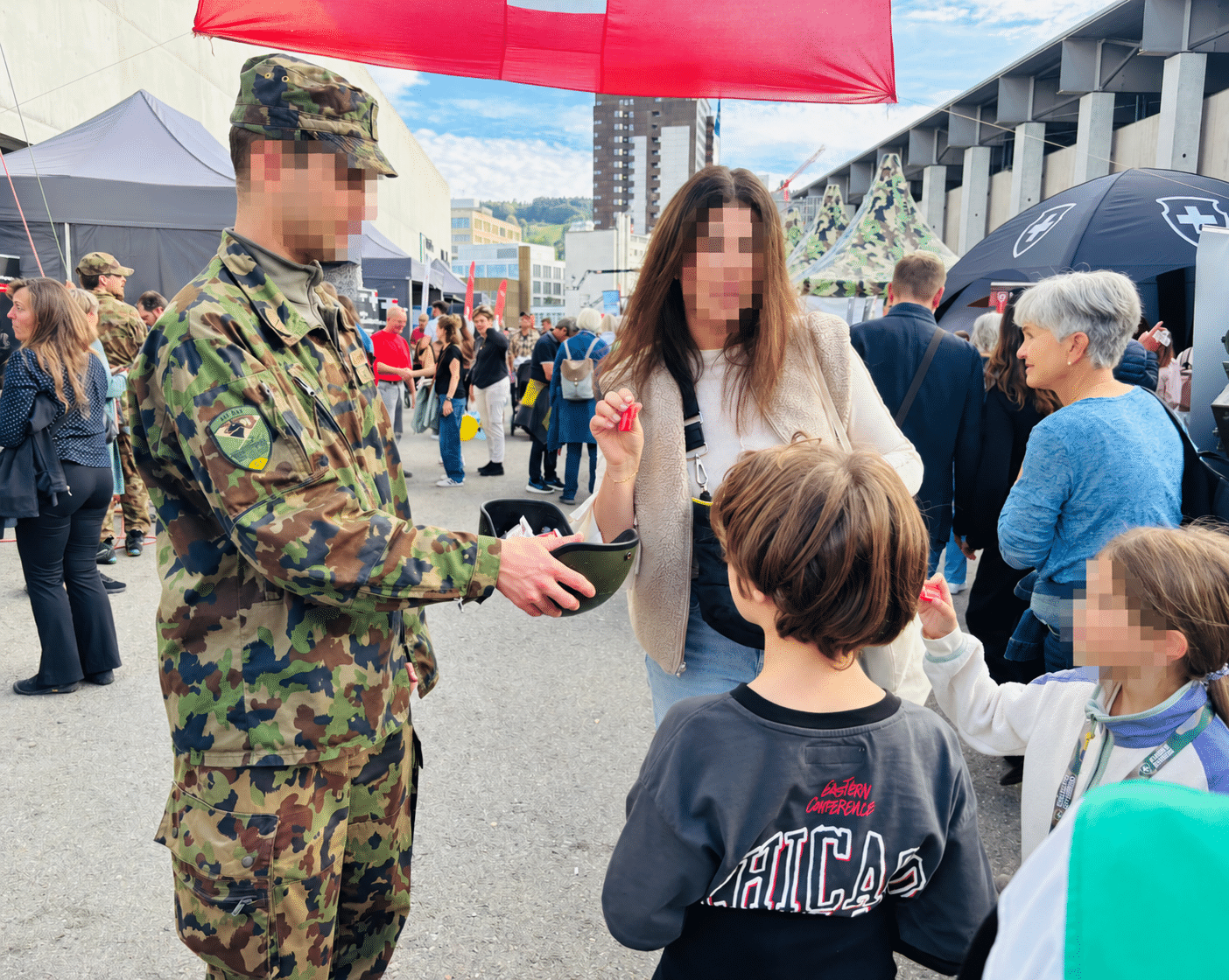 Armee auf Werbetour: Soldat verteilt Kindern Biscuits an einer Messe